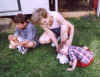 Two boys and their grandma play with bunnies.