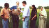 Bob holds large lamb while friends look on.