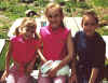 Three kids hold a bunny.