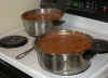 Big sauce pans of simering tomatos with fresh herbs.